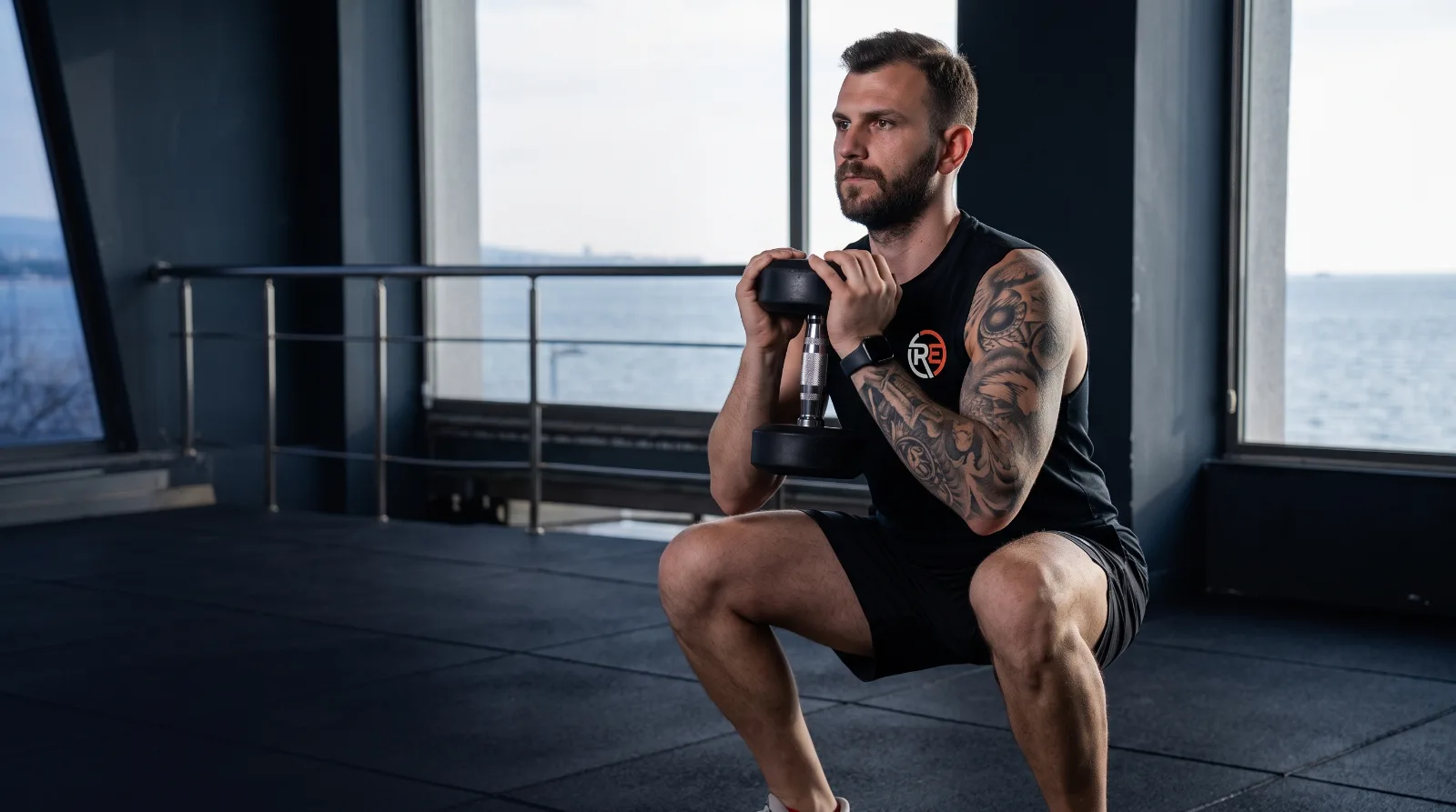 Ruhi Eriş stüdyoda dambılla goblet squat yapıyor
